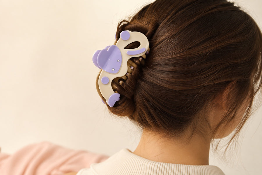 Cream and lilac rhinestone claw clip styled in a polished dark-brown hair twist