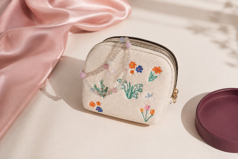 Cream botanical embroidered jewelry travel case on an almond and blush vanity