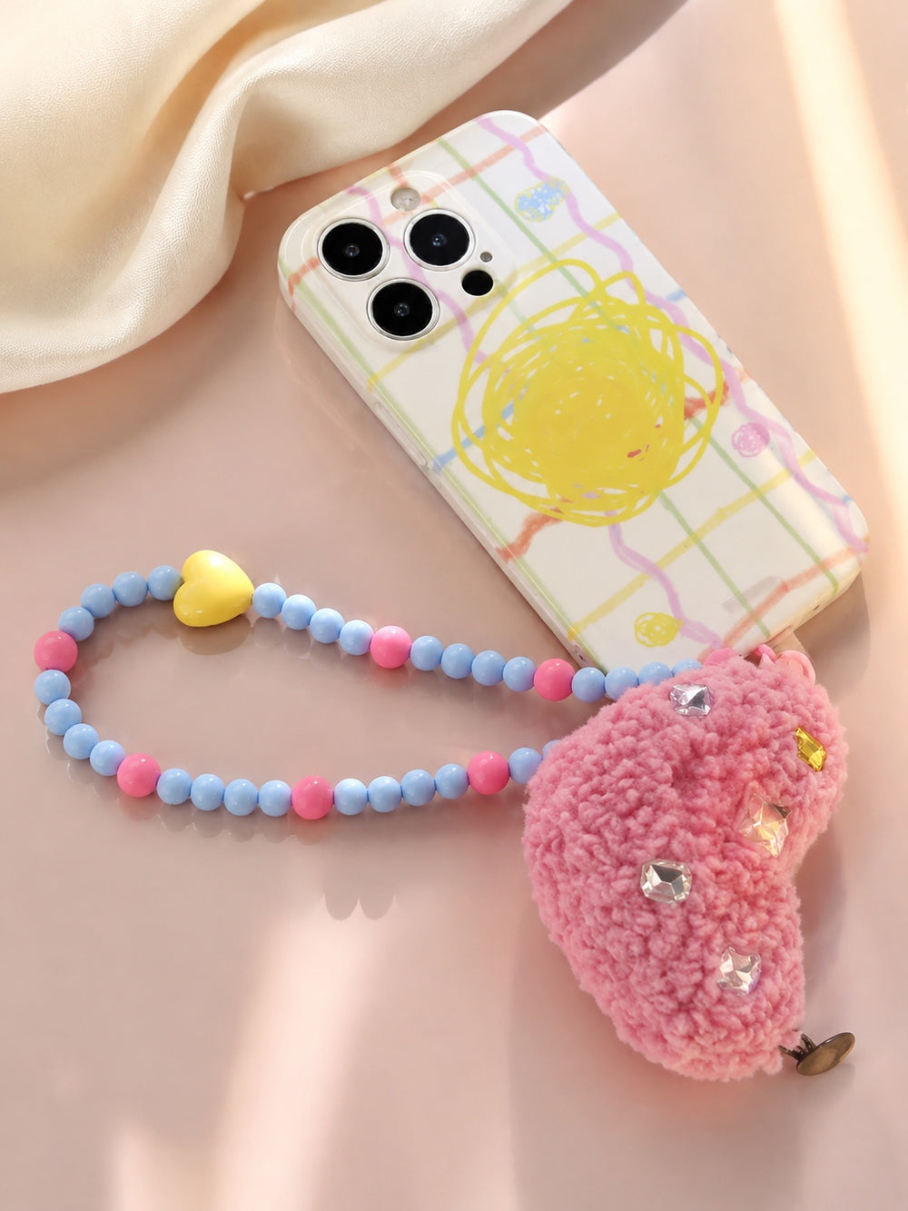 Blue and pink beaded phone wrist strap with a yellow heart bead and fuzzy pink heart charm